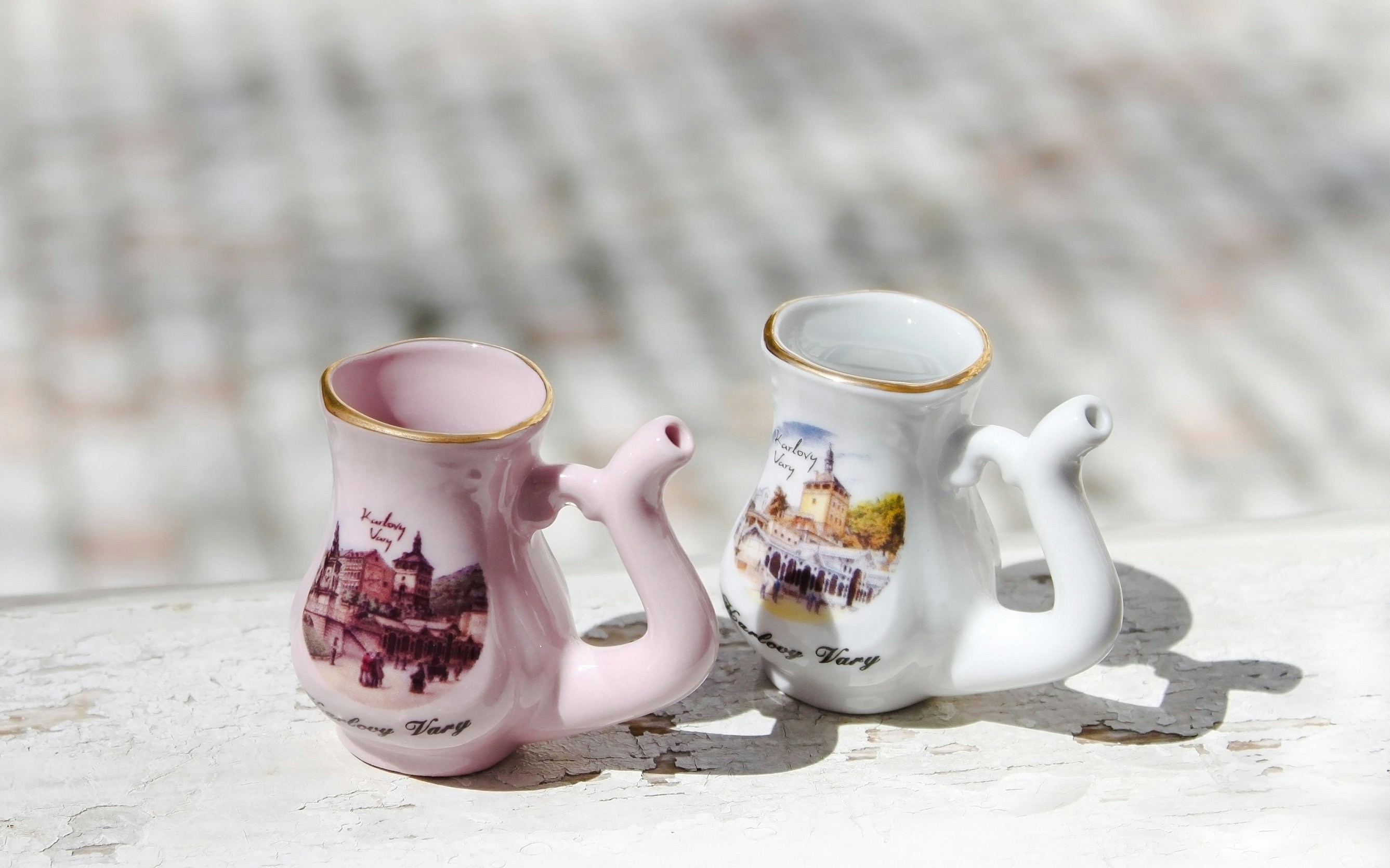 Porcelain souvenir mugs with Karlovy Vary landmarks.