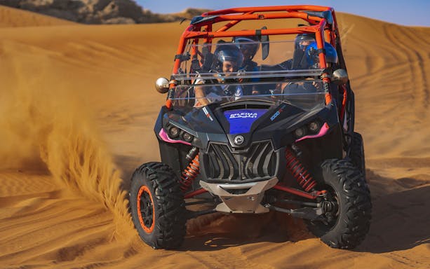 Dune buggy driving through sand dunes on a self-drive tour in Mleiha.