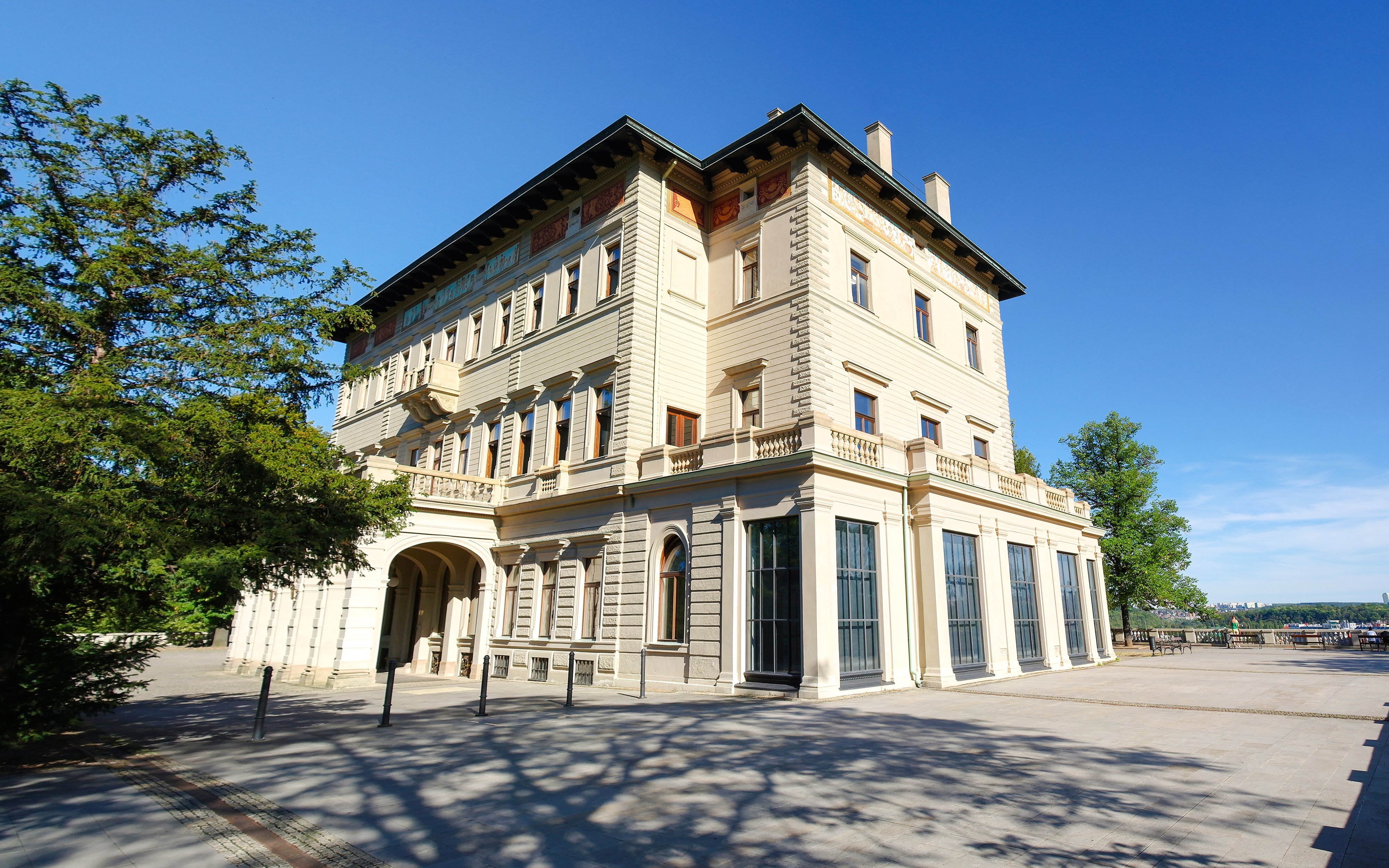 Villa Lützow exterior with trees and clear sky in the background.