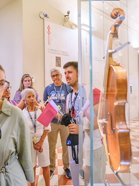 Tour group with guide viewing musical instruments at Accademia Gallery.