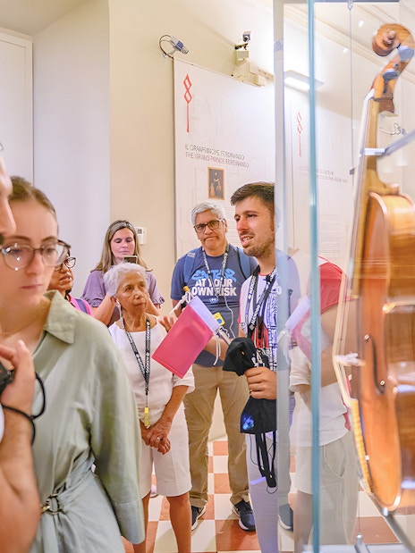 Tour group with guide viewing musical instruments at Accademia Gallery.