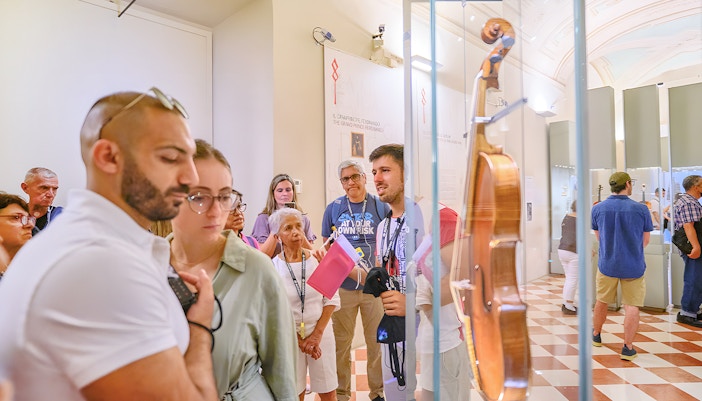 Tour group with guide viewing musical instruments at Accademia Gallery, Florence.