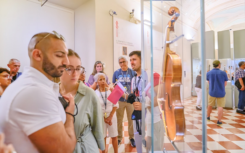 Tour group with guide viewing musical instruments at Accademia Gallery.