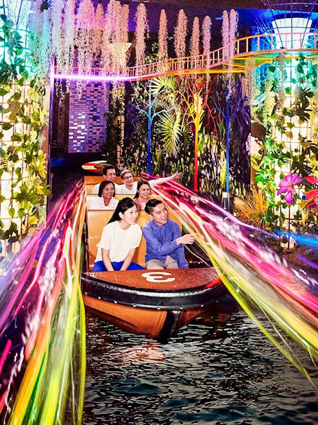 Boat ride through vibrant lights and foliage at Madame Tussauds Singapore.