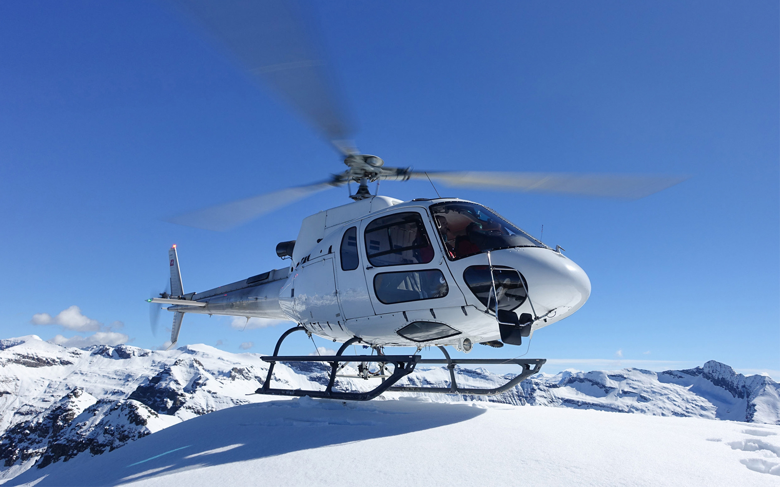 Helicopter flying over snowy peaks near the Matterhorn.