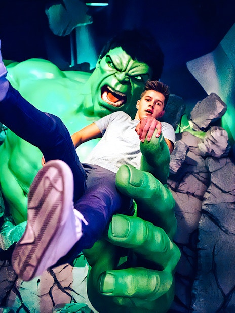 Man posing with Hulk figure at Madame Tussauds.