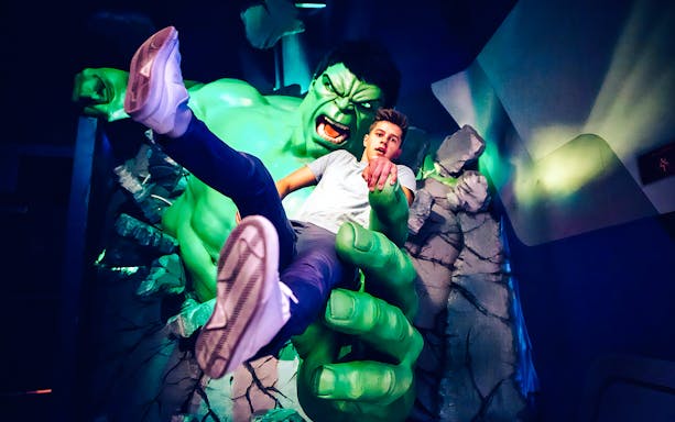 Man posing with Hulk figure at Madame Tussauds.