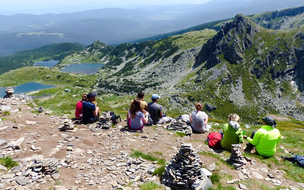 Hikers resting with a view of the Seven Rila Lakes during a tour from Sofia.