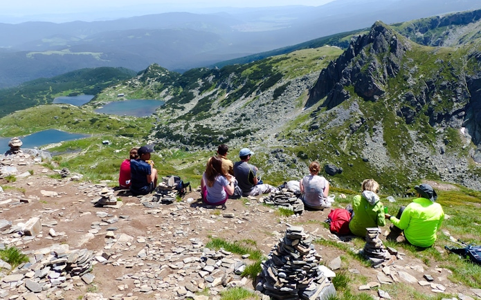 Hikers resting with a view of the Seven Rila Lakes during a tour from Sofia.