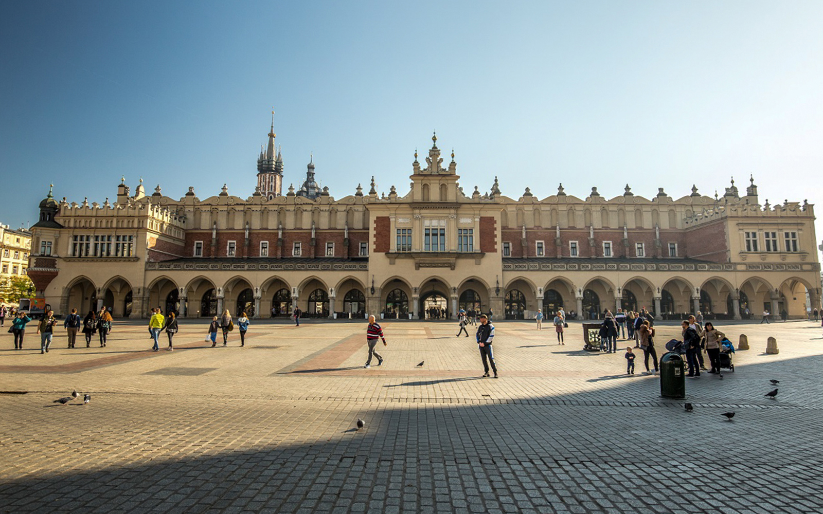 Krakow's Cloth Hall in the Main Market Square with people walking.