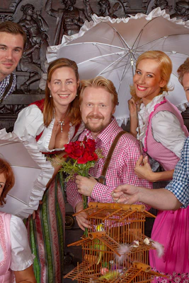 Performers in traditional attire with umbrellas at Vienna city hall dinner show.