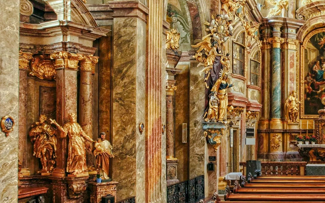 Ornate interior of St Anne's Church with gilded statues and detailed columns.