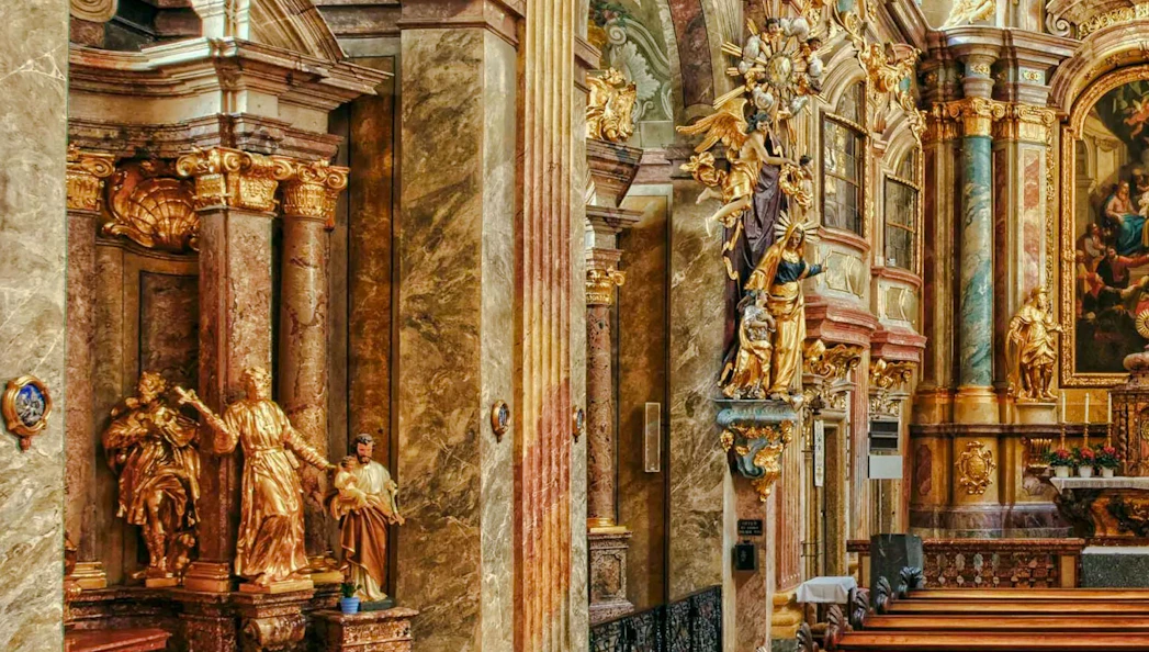 Ornate interior of St Anne's Church with gilded statues and detailed columns.