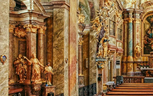 Ornate interior of St Anne's Church with gilded statues and detailed columns.