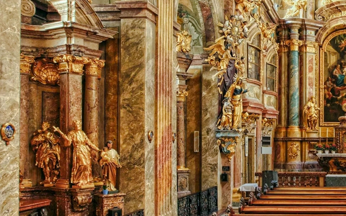 Ornate interior of St Anne's Church with gilded statues and detailed columns.