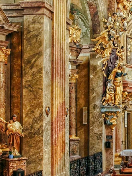 Ornate interior of St Anne's Church with gilded statues and detailed columns.