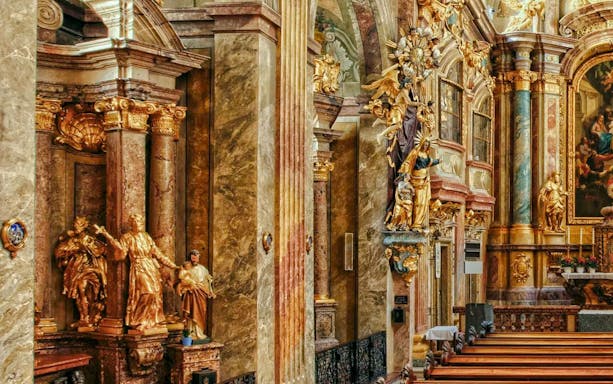 Ornate interior of St Anne's Church with gilded statues and detailed columns.