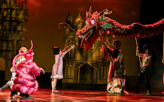 Performance of The Dragon Child with dragon puppet on stage in Sydney.