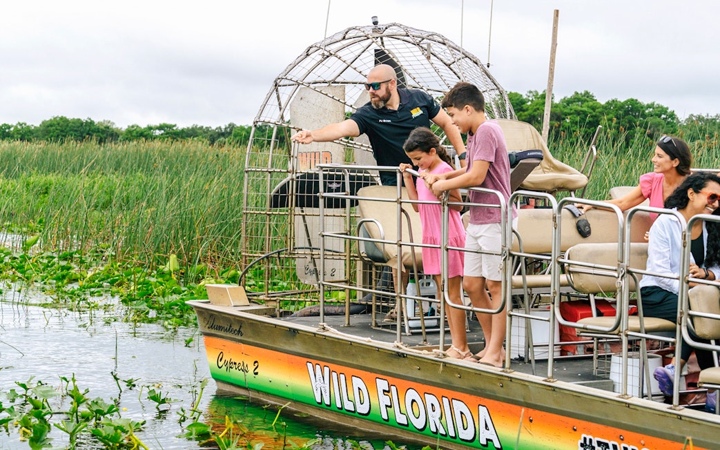 Guests on an airboat tour enjoying the Everglades view in Florida.