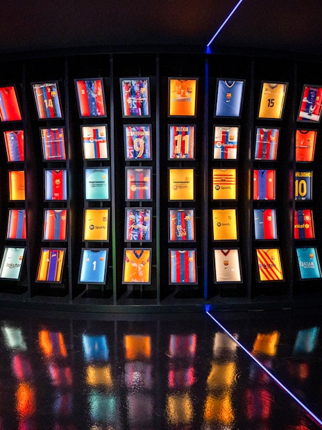 FC Barcelona jerseys displayed in a curved exhibit at the immersive tour.