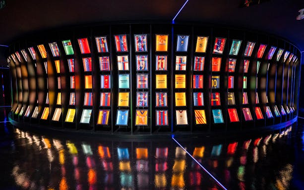 FC Barcelona jerseys displayed in a curved exhibit at the immersive tour.