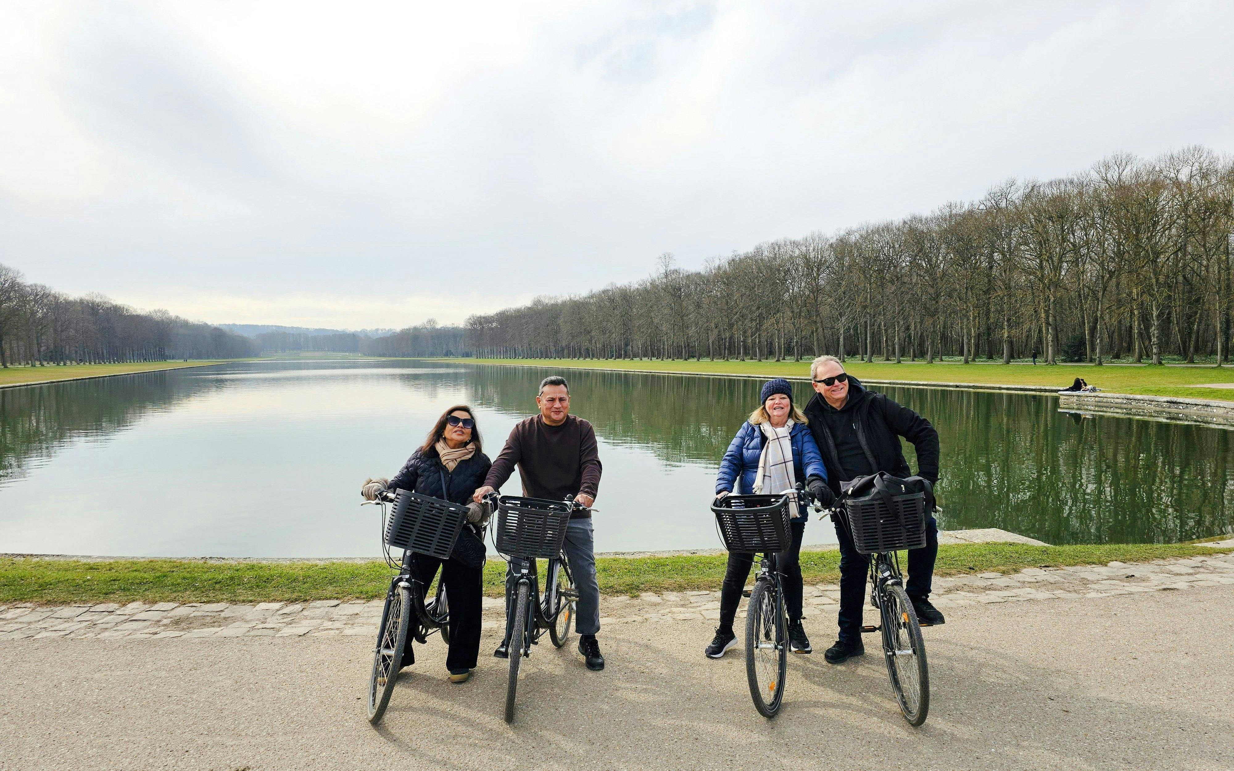 Bikers by the Grand Canal in Versailles Gardens during guided tour.