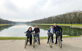 Bikers by the Grand Canal in Versailles Gardens during guided tour.