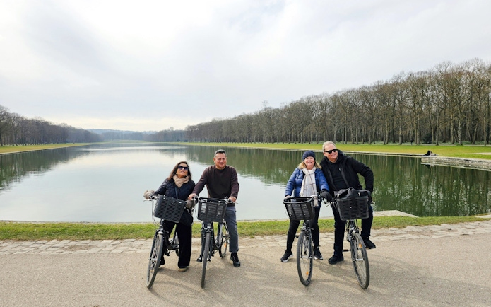 Bikers by the Grand Canal in Versailles Gardens during guided tour.