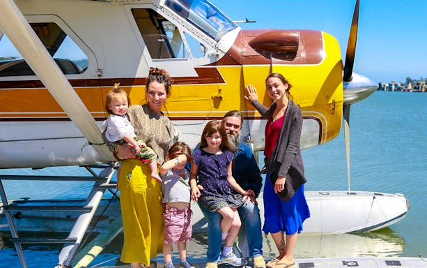 Family posing by seaplane on Golden Gate Seaplane Tour, San Francisco Bay.