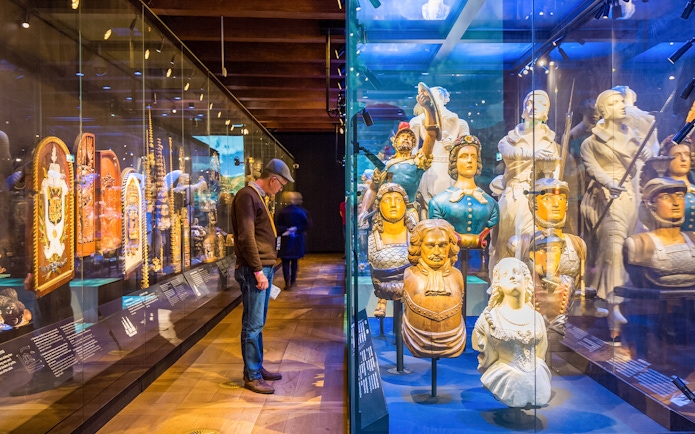 Figureheads and maritime artifacts on display at The Maritime Museum, Amsterdam.