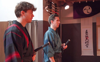 Participants in traditional attire holding swords during Tokyo Samurai Experience.