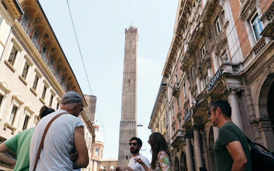 Group on a guided food tour near Asinelli Tower in Bologna.