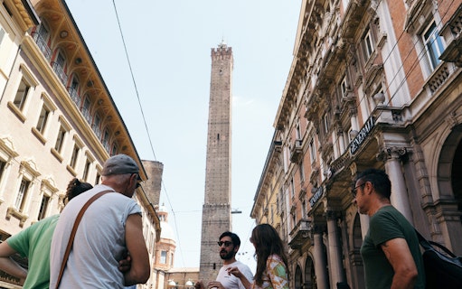 Group on a guided food tour near Asinelli Tower in Bologna.