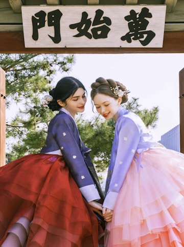 Two people in traditional hanbok at Gyeongbokgung Palace, Seoul.