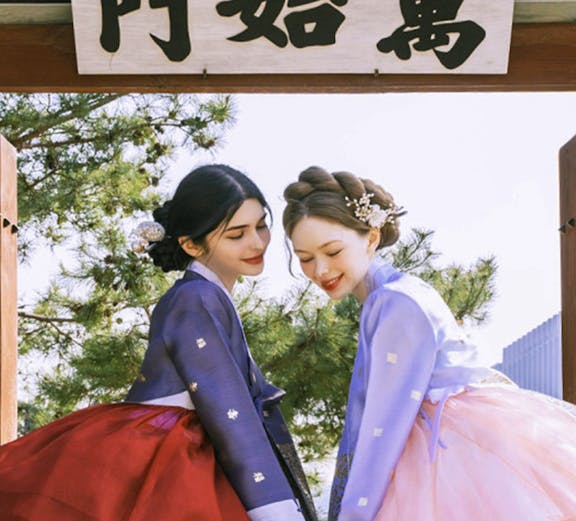 Two people in traditional hanbok at Gyeongbokgung Palace, Seoul.