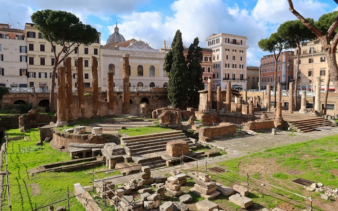Ruins of ancient temples in Largo di Torre Argentina, Rome, with surrounding buildings.