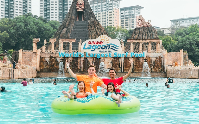 Family enjoying a float ride at Sunway Lagoon's surf pool, Malaysia.