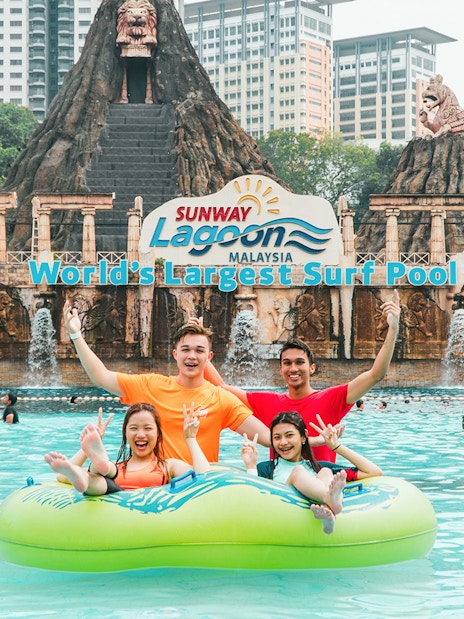 Family enjoying a float ride at Sunway Lagoon's surf pool, Malaysia.