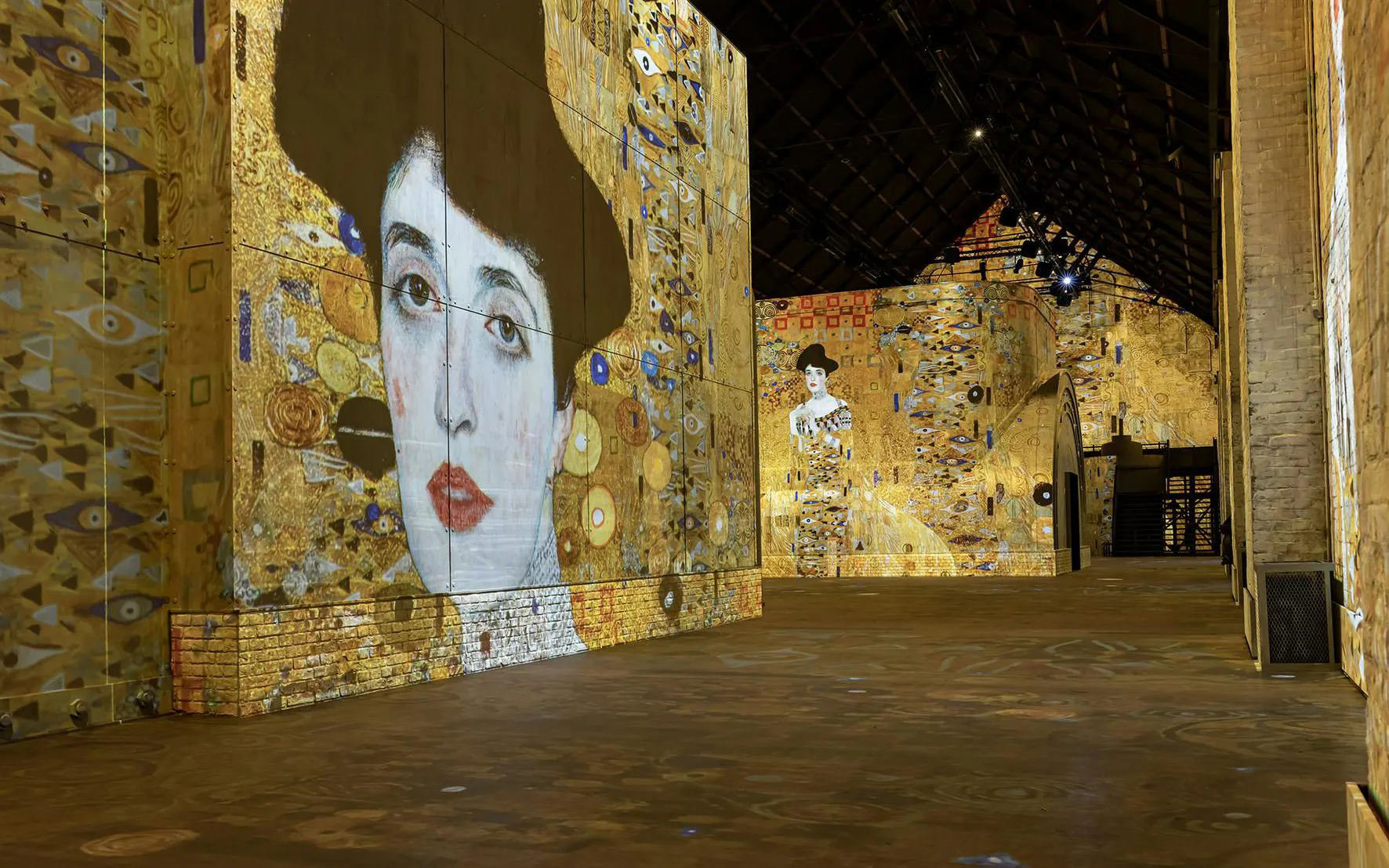 Immersive art projections at Fabrique des Lumières featuring Klimt's portraits.
