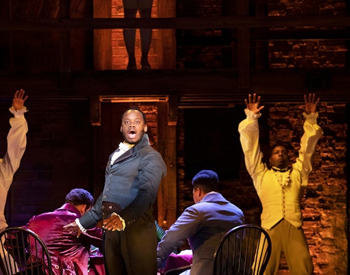 Cast performing Hamilton musical on stage in London theater.