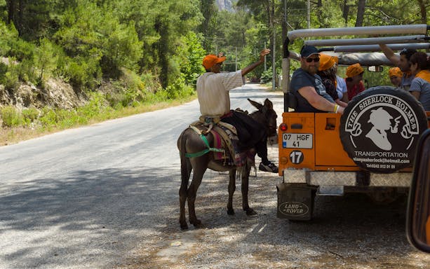 Jeep safari group interacting with a local on a donkey in Antalya countryside.