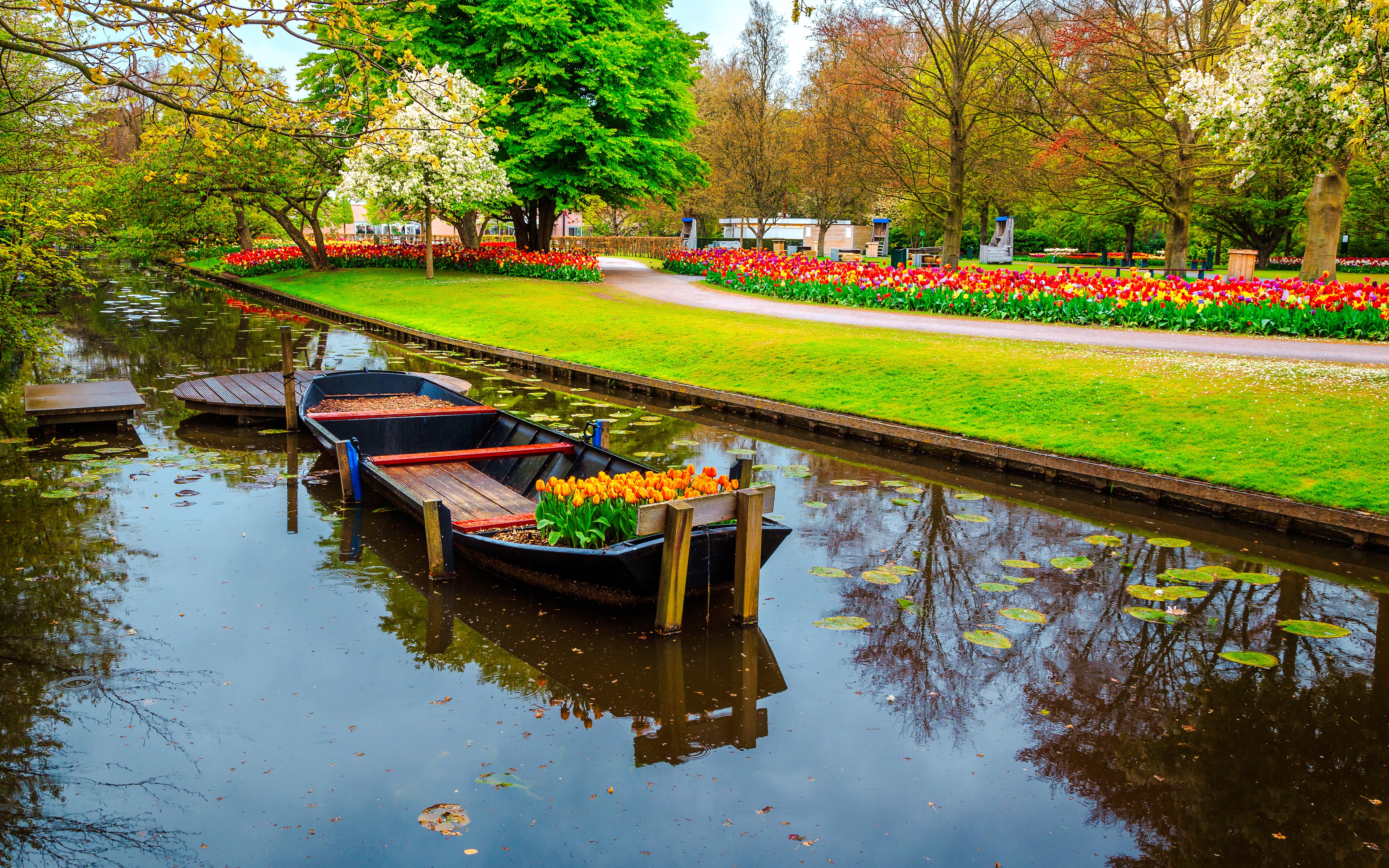 Whisper boat on canal surrounded by tulip gardens at Keukenhof.