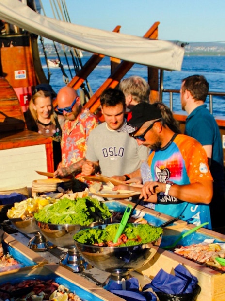 People enjoying seafood buffet on Oslofjord dinner cruise.
