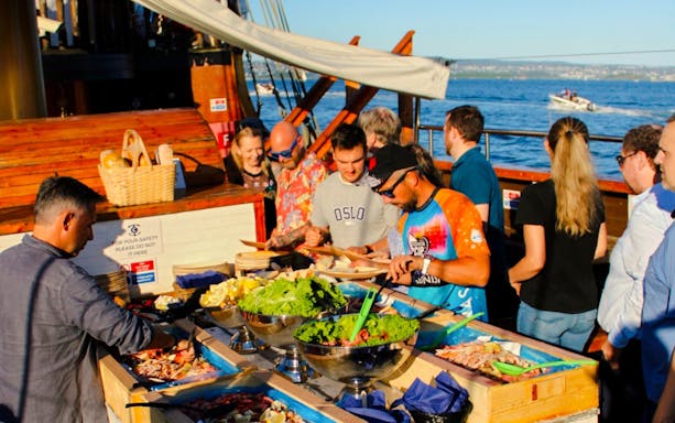 People enjoying seafood buffet on Oslofjord dinner cruise.
