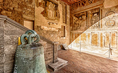 Volterra museum interior with ancient bell and frescoes, part of Combo: Volterra Pass + San Gimignano Pass + San Pietro Museum Tickets.