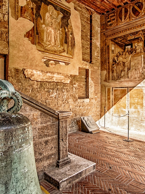 Volterra museum interior with ancient bell and frescoes, part of Combo: Volterra Pass + San Gimignano Pass + San Pietro Museum Tickets.