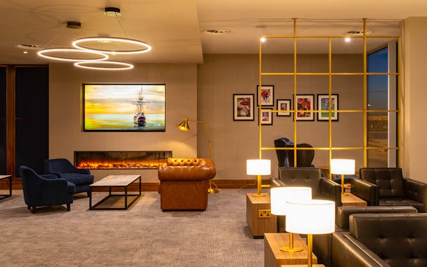 Plaza Premium Lounge seating area at Edinburgh Airport with modern decor and ambient lighting.