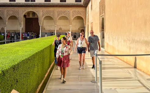 Tourists with guide walking at Alhambra, Granada, during guided tour without Nasrid Palaces.
