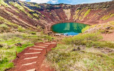 Kerid Crater with turquoise lake and surrounding red volcanic rock in Iceland.