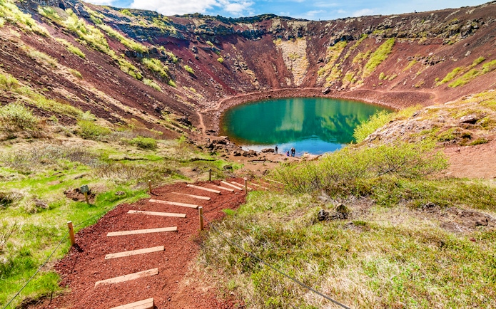 Kerid Crater with turquoise lake and surrounding red volcanic rock in Iceland.